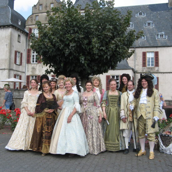Gruppenbild der Tänzer in Kostümen vor dem Schloss