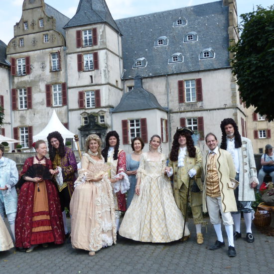 Gruppenbild der Tänzer vor einer Schlosskulisse